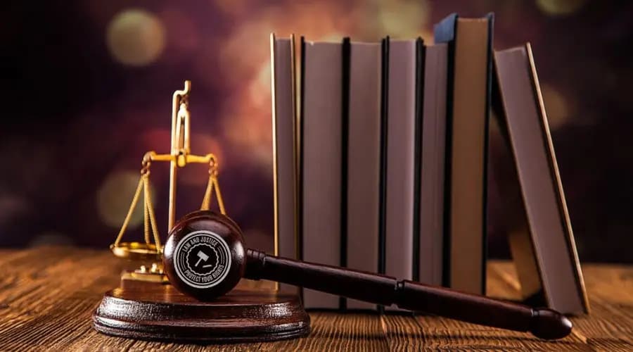 A judge’s gavel, law books, and scale of justice placed on a wooden desk, symbolising the rule of law and judicial integrity.
