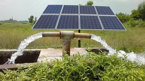 A solar-powered water pump irrigating farmland, symbolise India’s PM-KUSUM scheme promoting renewable energy in agriculture.