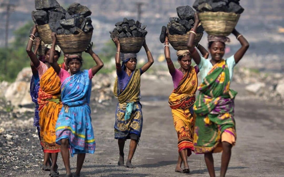 Women labourers carrying baskets of coal on their heads, symbolising India’s workforce and challenges to workers’ rights.