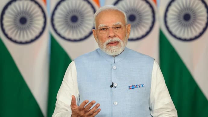 Prime Minister addressing an event with Indian flags in the background, emphasising India’s vision to become a global  hub.